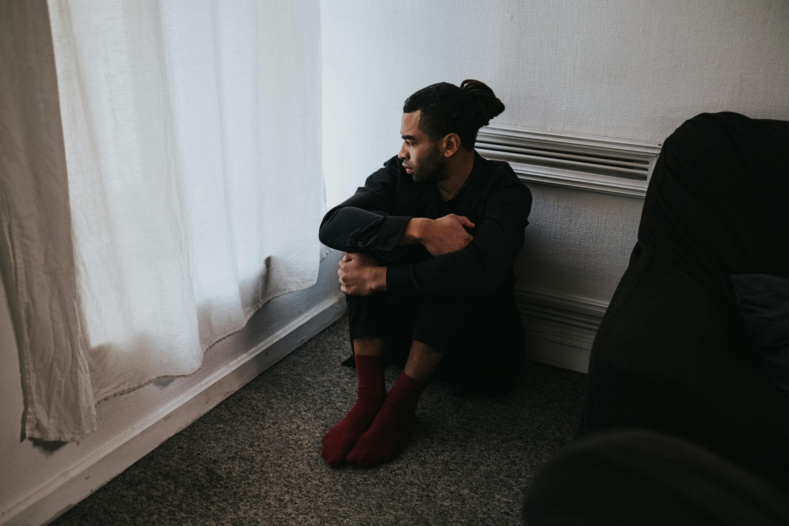 Man sitting in corner of room